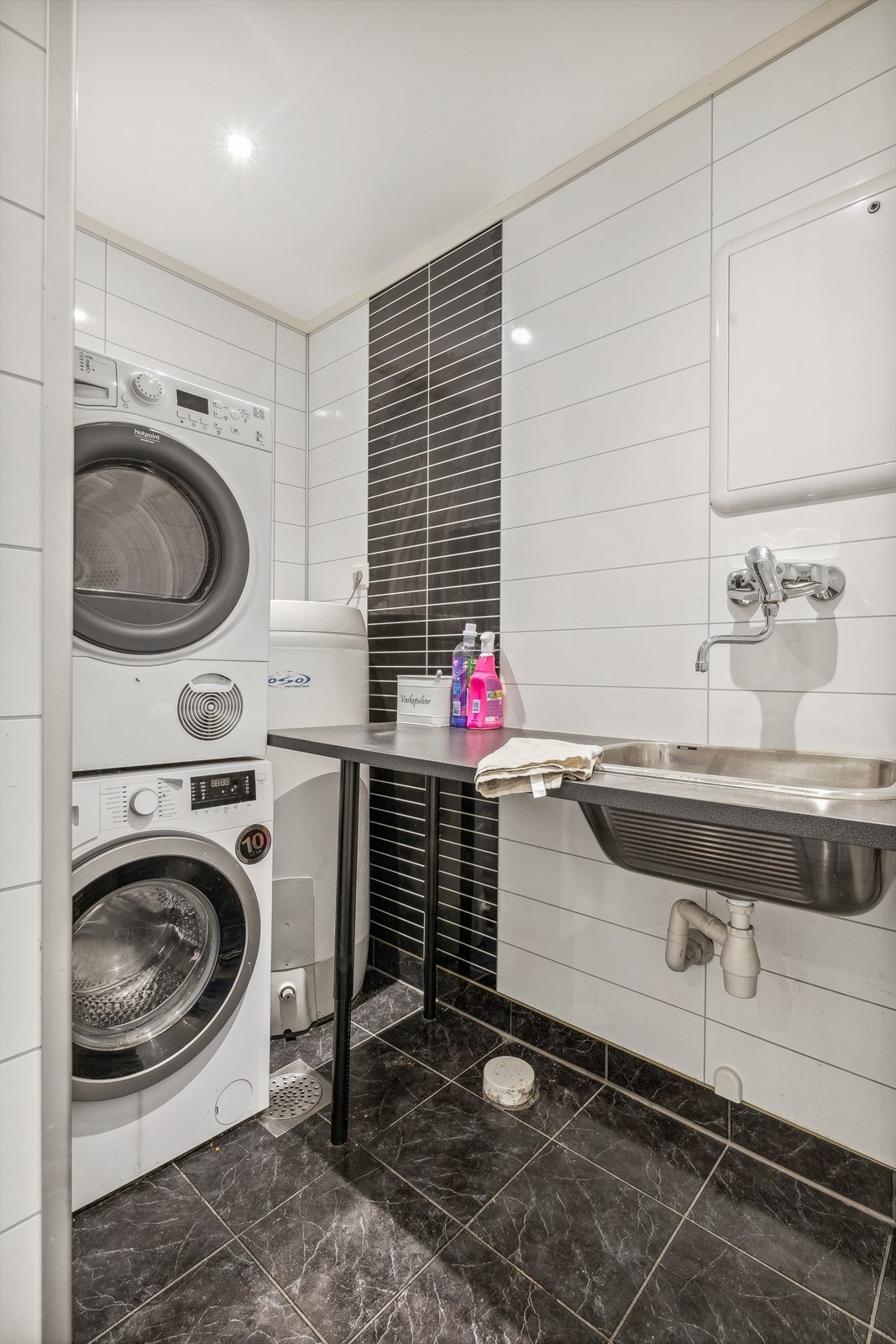 Badet er innredet med servant med møblement/speil, vegghengt toalett, dusjnisje med garnityr, utslagsvask og opplegg for vaskemaskin. Galleribilde