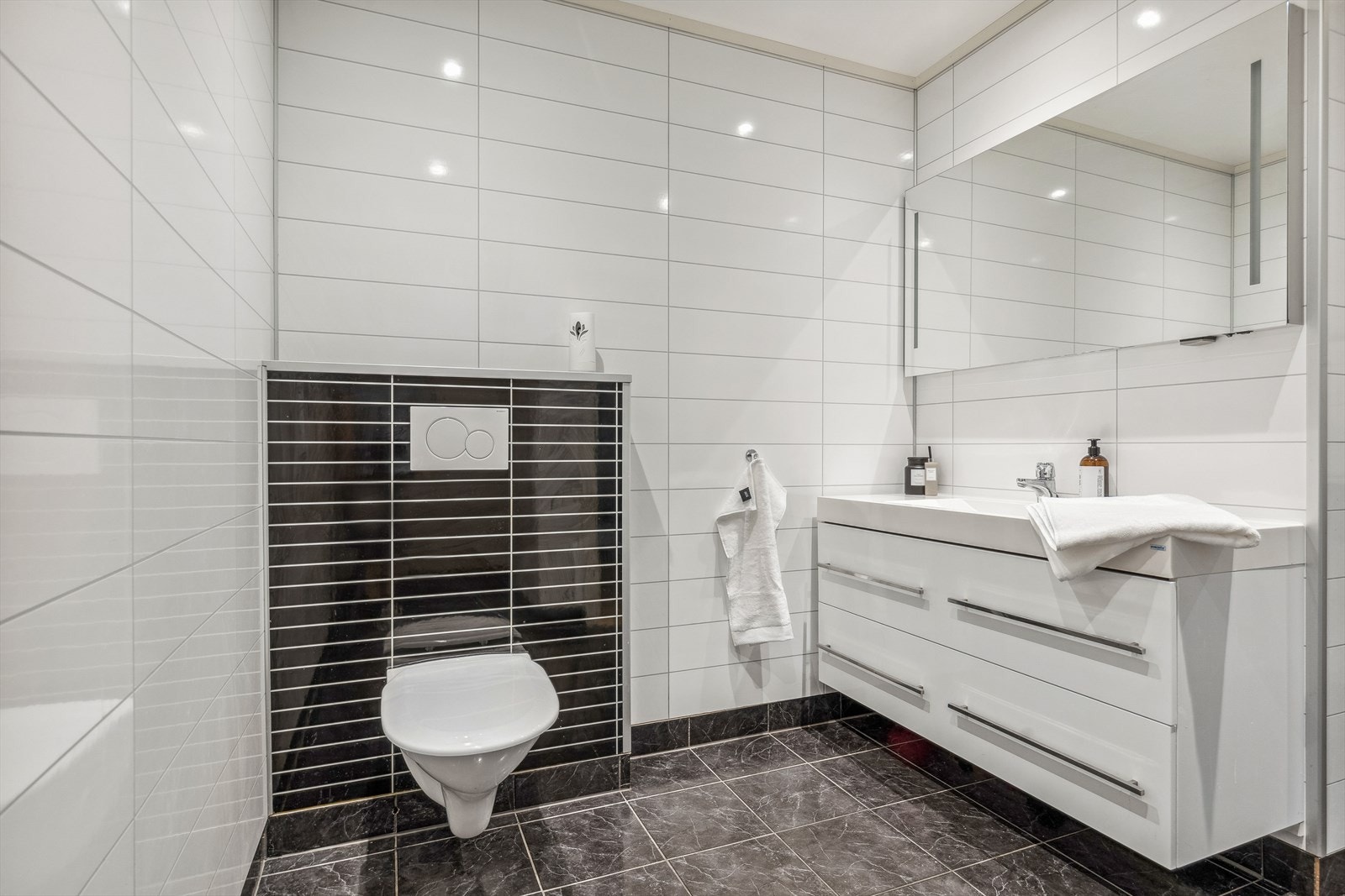 I underetasje er det bad som har fliser på gulv og baderomsplater på vegger. Det er varmekabler i gulv og spotlights i himling. Galleribilde