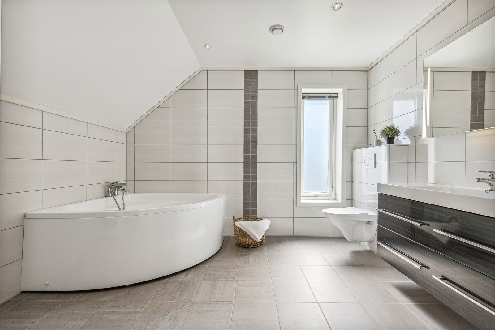 Baderom som er helfliset med varmekabler i gulv og innfelte spotlights i himling. Galleribilde