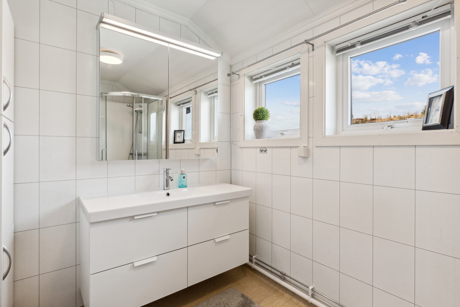 Bad med baderomsplater på vegg og belegg på gulv Galleribilde
