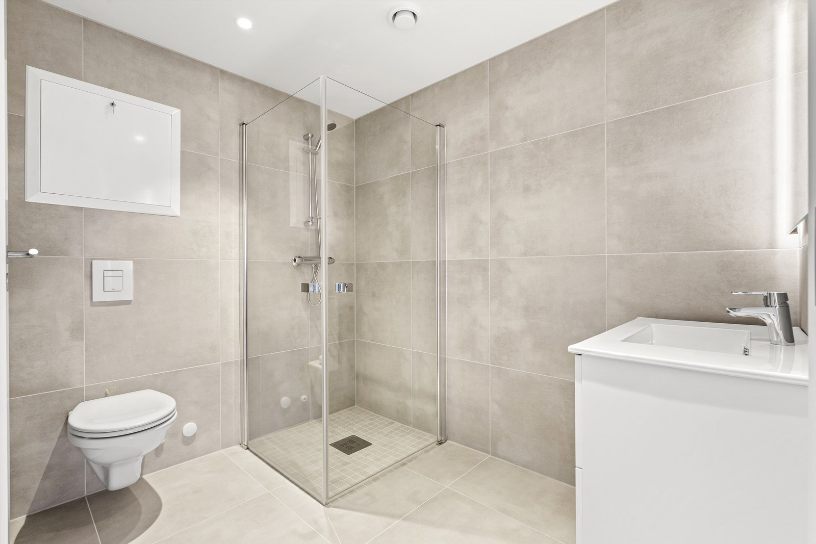 Badet på innsiden av hovedsoverommet har flis på gulv og vegg Galleribilde