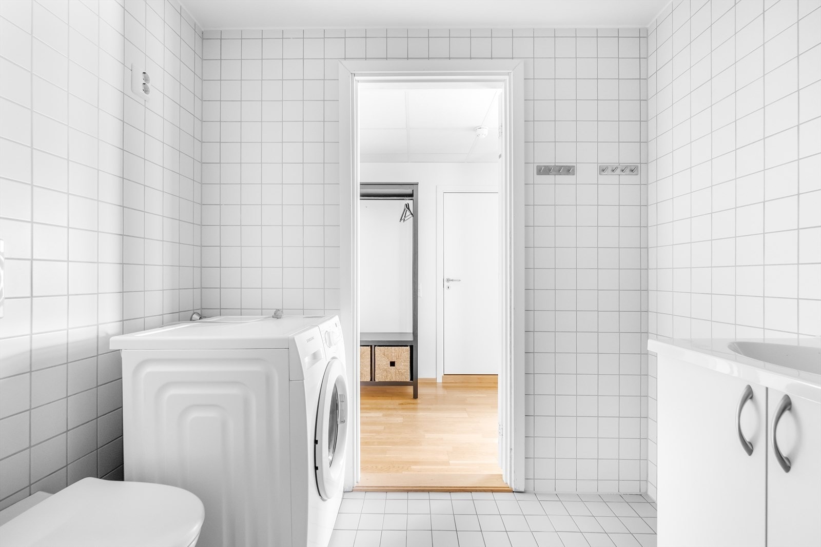 Badet er innredet med vegghengt toalett, dusjhjørne, servant i underskap samt speil med lys i rommet. Galleribilde