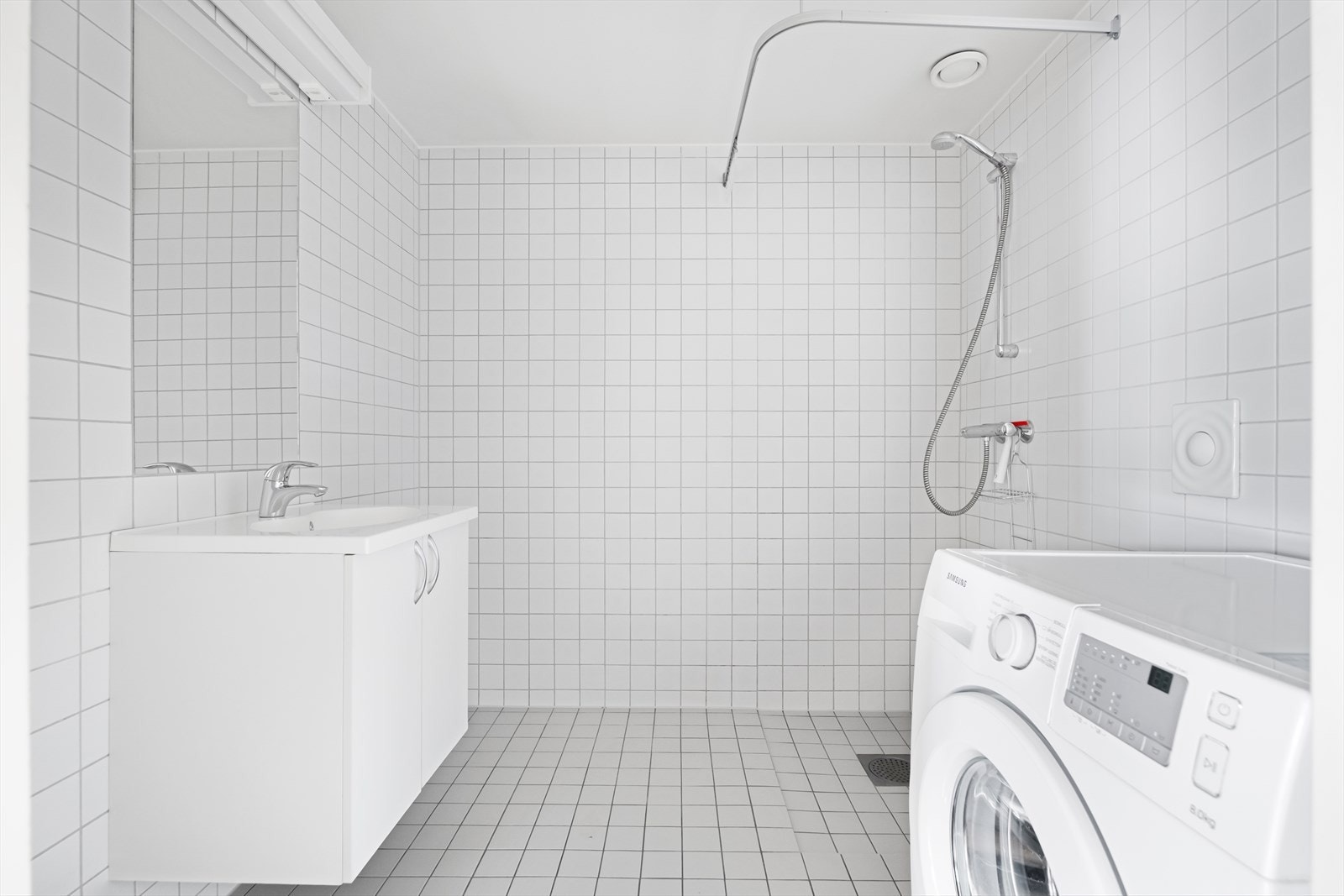 Lys og stilren baderomsmodul med flislagte overflater og varmekabler i gulv. Det er opplegg for vaskemaskin på badet. Galleribilde
