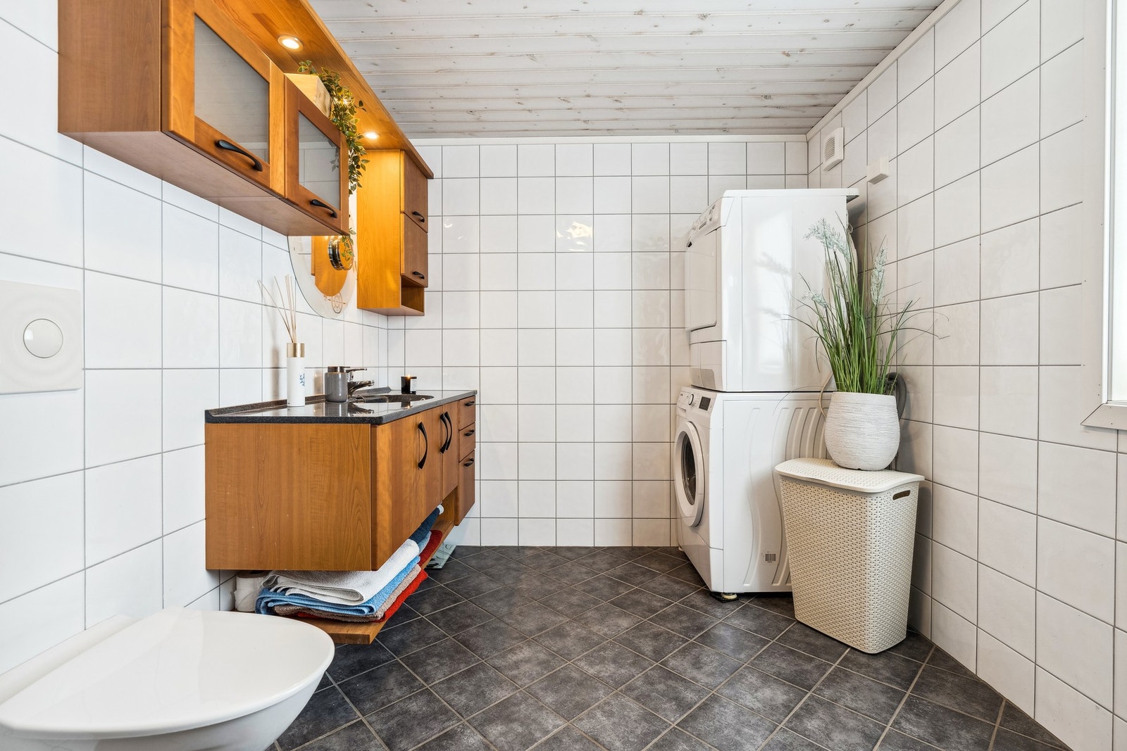 Romslig og flislagt bad med varmekabler i gulv. Stor baderomsinnredning med god oppbevaringsplass. Opplegg for vaskemaskin og tørketrommel. Galleribilde