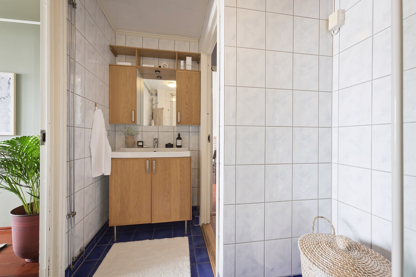 Innredning med dusjkabinett, servant med underskap og speil med skap på hver side. Galleribilde