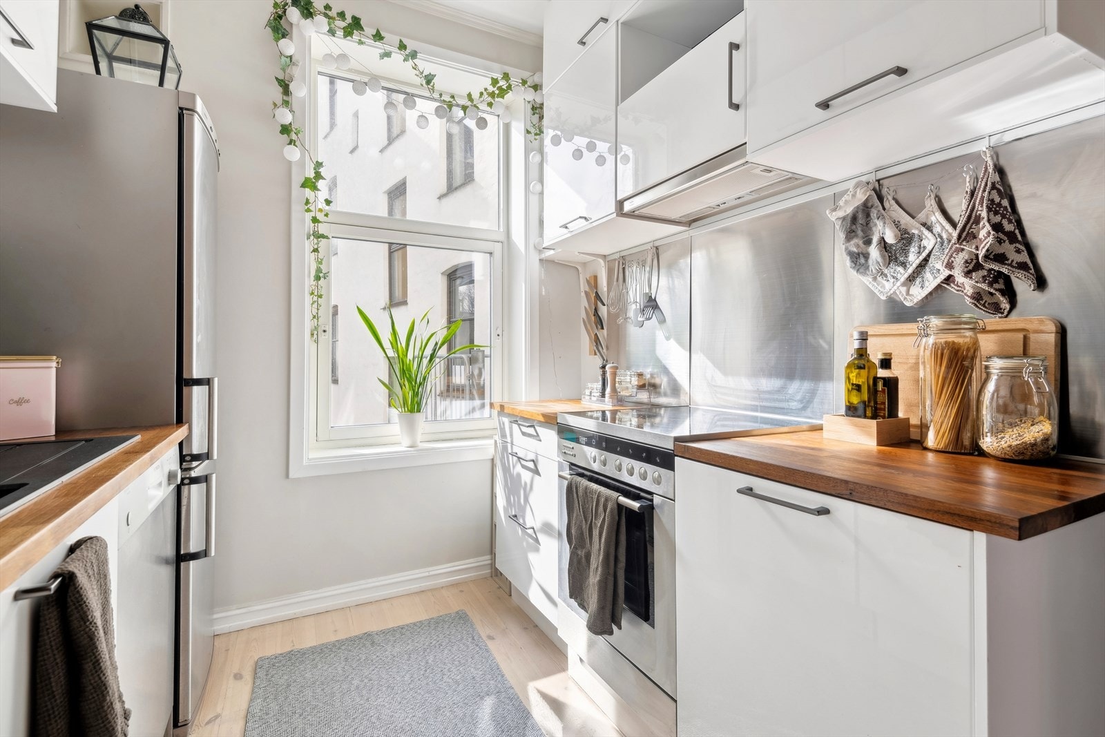 Kjøkkeninnredningen har hvite glatte fronter, benkeplaten er i laminat. Galleribilde