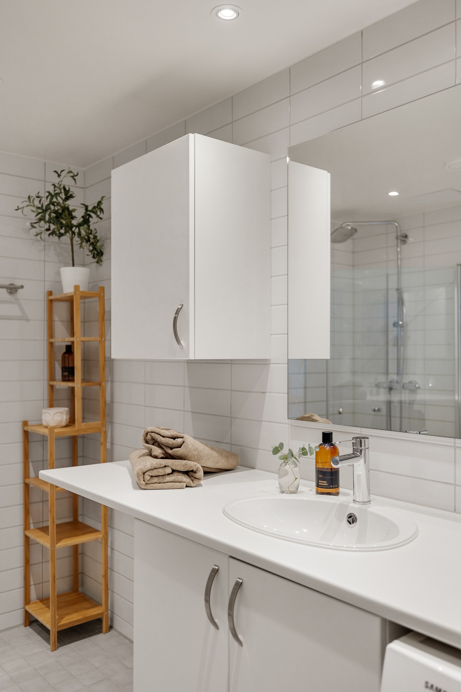 Moderne baderomsinnredning med skap, servant og speil. Downlights med dimmer i himling. Galleribilde