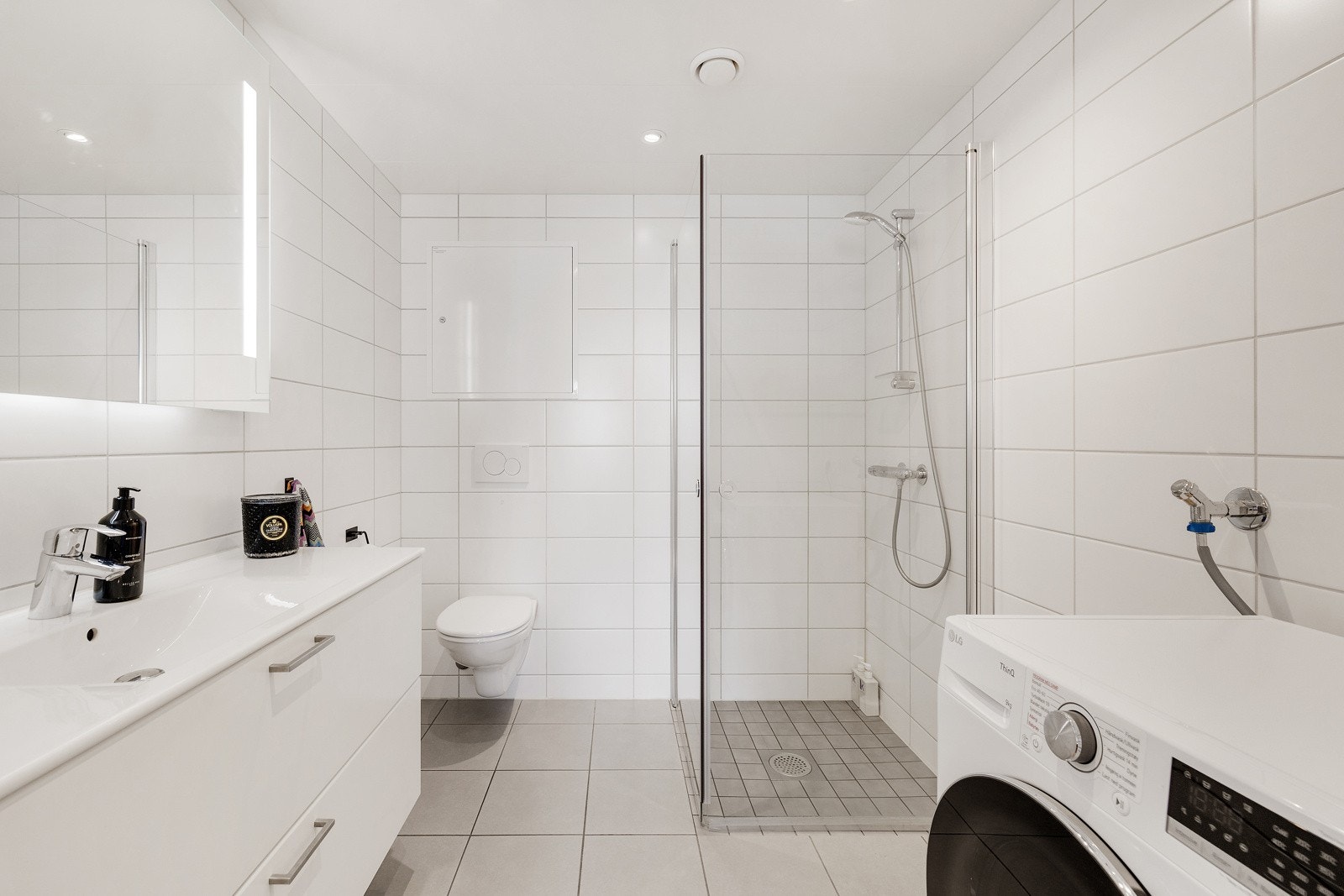Badet har vegghengt toalett og dusjhjørne med glassvegger. Galleribilde