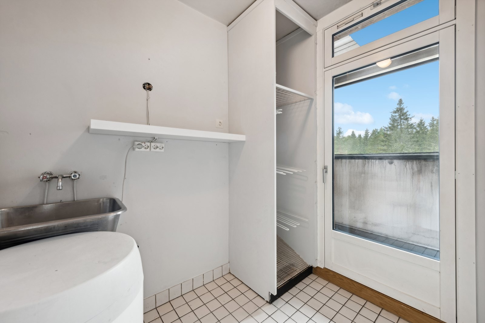 Vaskerommet har malte flater og fliser på veggene, og fliser på gulvet. Her finner du utslagsvask og plass for vaskemaskin. Galleribilde