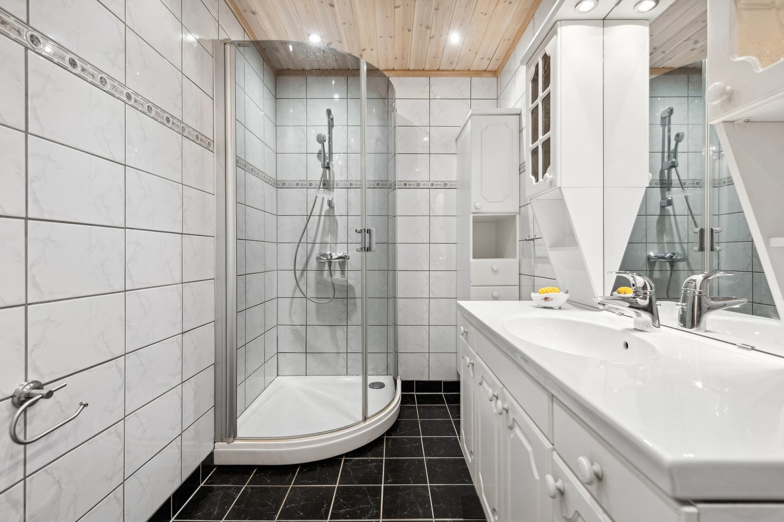 BAD | Badet fra 2007 er pent flislagt med behagelig varme i gulvet. Det er innredet med servant med skapinnredning, speil, dusjkar, Veggmonterte dusjvegger og veggmontert klosett. Galleribilde