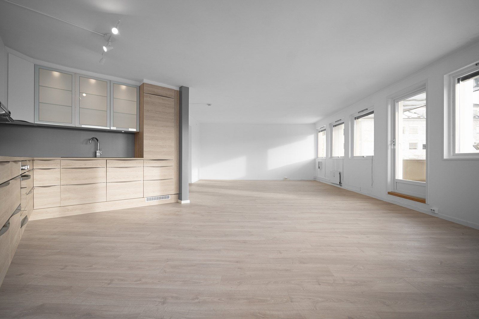 Innredningen har glatte fronter og laminert benkeplate med nedfelt oppvaskkum. Praktisk med takhøye overskap med belysning under. Galleribilde