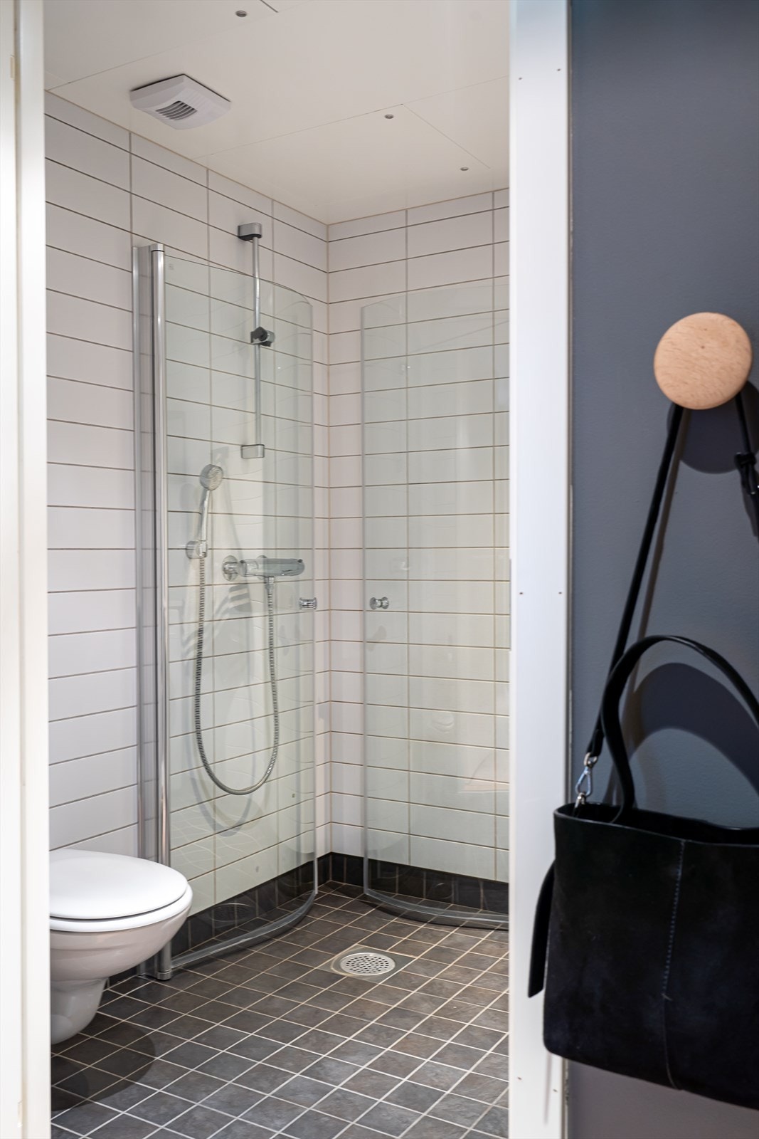 Videre er rommet utstyrt med stikk, dusjhjørne med innfellbare dusjvegger, vegghengt toalett og opplegg for vaskemaskin. Galleribilde