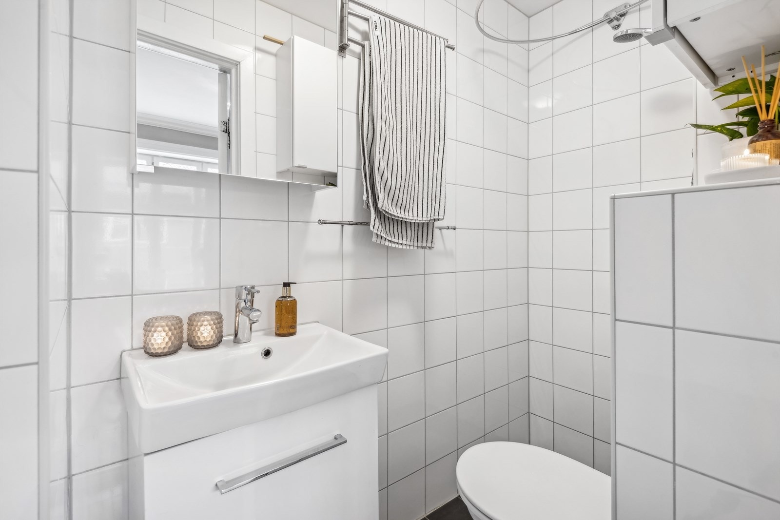 Pent fliselagt baderom med nøytrale fliser. Badet er fra 2014 og er gjort av borettslaget. Galleribilde