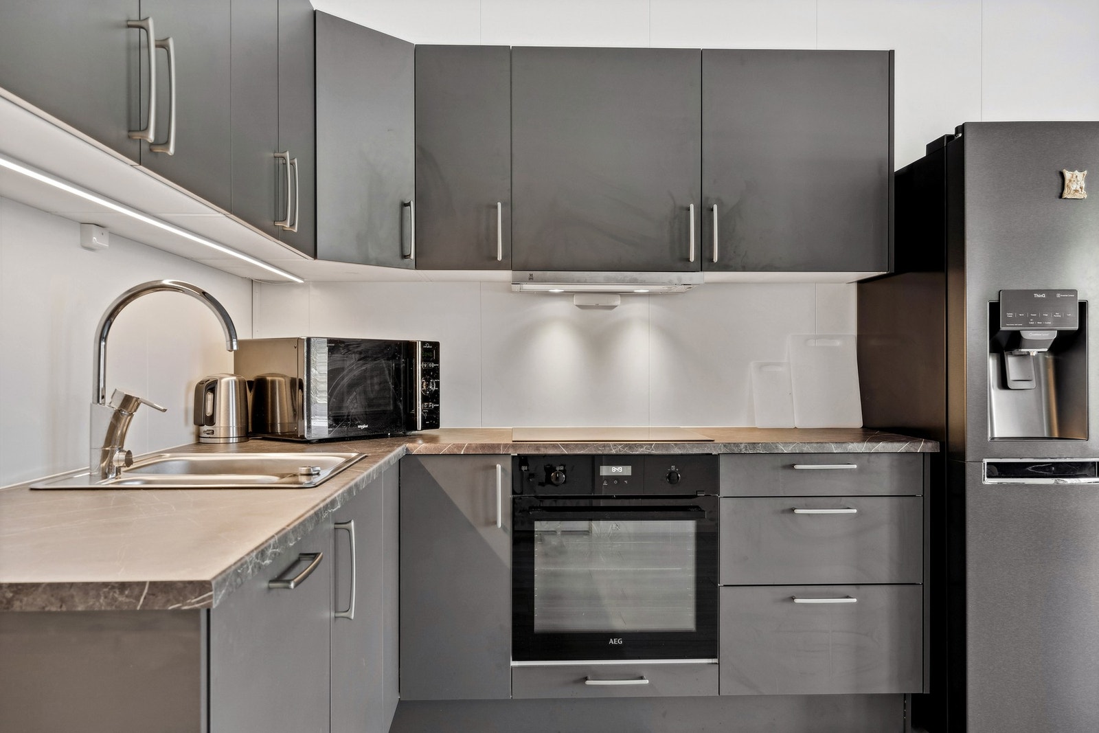 Kjøkkenet har integrerte hvitevarer - koketopp, stekeovn, oppvaskmaskin og kombiskap kjøl/frys med isvann og isbiter medfølger i salget Galleribilde