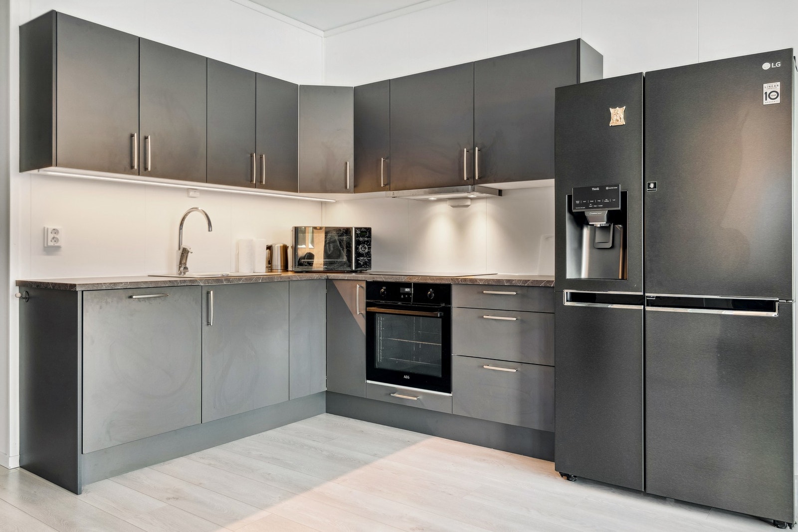 Kjøkkenet har integrerte hvitevarer - koketopp, stekeovn, oppvaskmaskin og kombiskap kjøl/frys med isvann og isbiter medfølger i salget Galleribilde