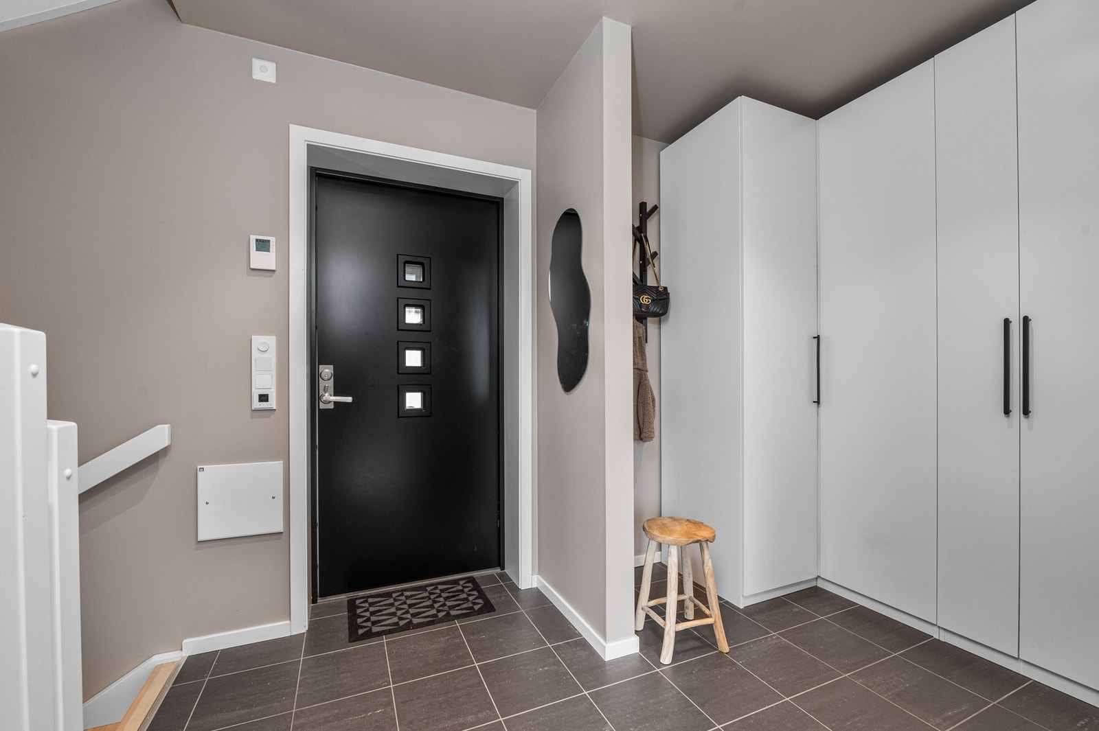 Romslig og flislagt inngangsparti med gulvvarme. Her er det montert et stort garderobeskap med gode oppbevaringsmuligheter. Galleribilde