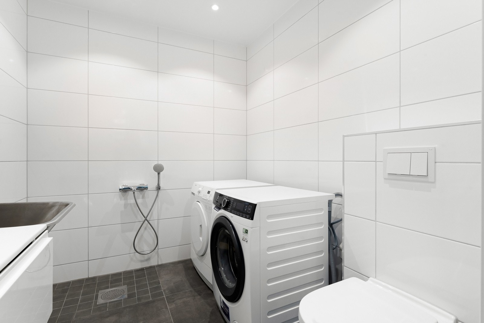 Det andre våtrommet nede er et kombinert bad/vaskerom med utslagsvask, opplegg for vaskemaskin og plass til tørketrommel. Galleribilde