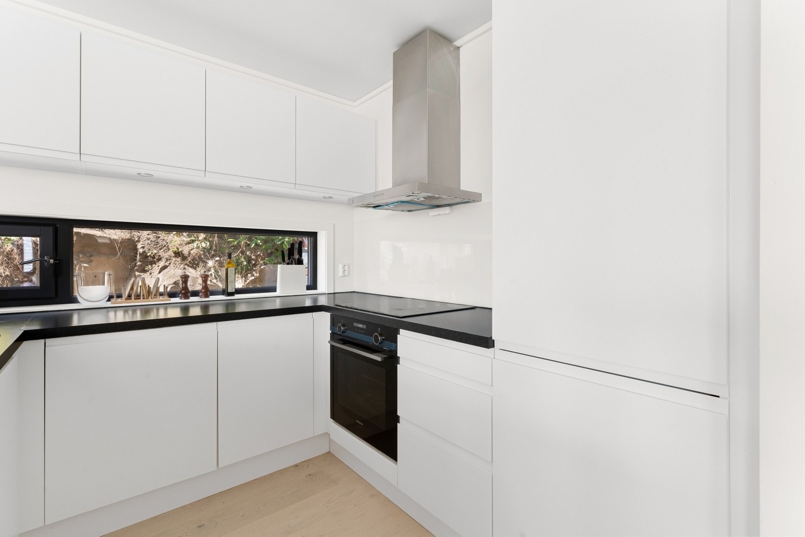 Kjøkkenet er moderne og meget funksjonelt med god skap- og benkeplass. Innredningen fra HTH har hvite, glatte fronter og soft close funksjon. Av hvitevarer har kjøkkenet integrert induksjonstopp, stekeovn, oppvaskmaskin og en kombinert kjøl/frys. Galleribilde