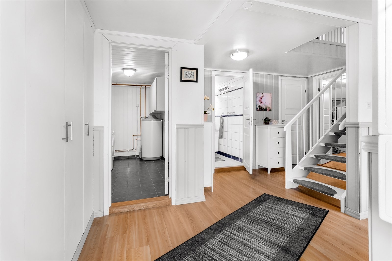 Videre er det trapp opp til 1. etasje, samt inngang til bad, vaskerom, boder og innredede rom. Galleribilde