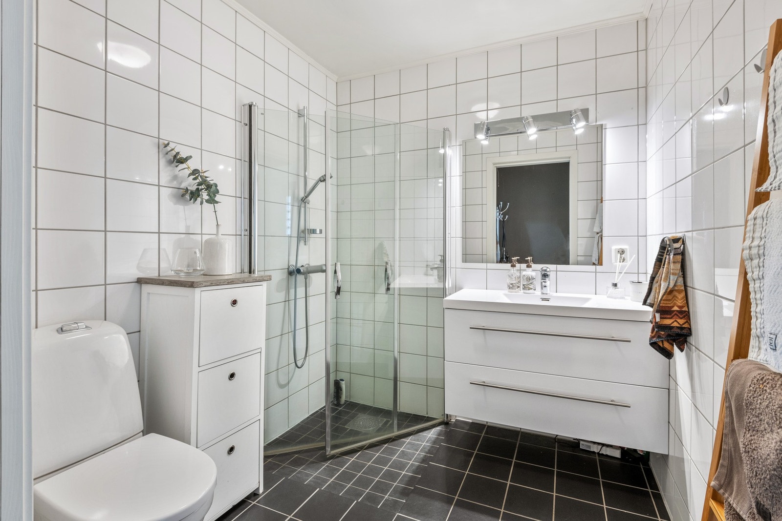 Badet er flislagt og har en lys og tidsløs innredning. Galleribilde