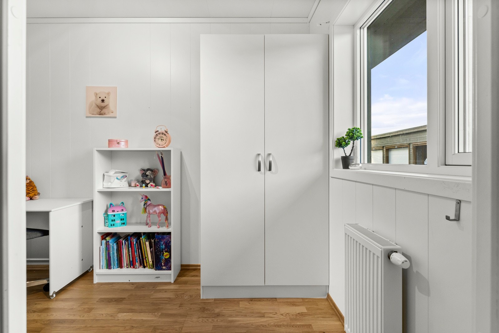 Soverom nr 2 er i dag et barnerom i lyse farger og med garderobe Galleribilde