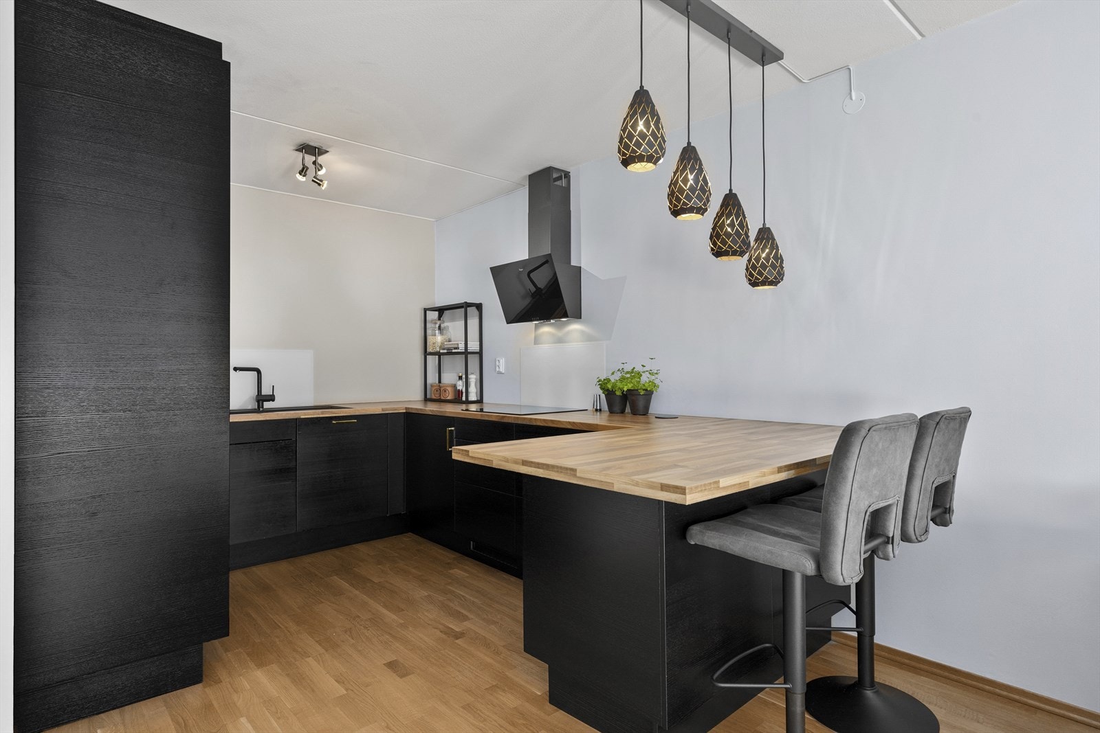 Kjøkkeninnredning har sorte fronter og laminat benkeplate. Det er godt med skapplass og benkplass. Galleribilde