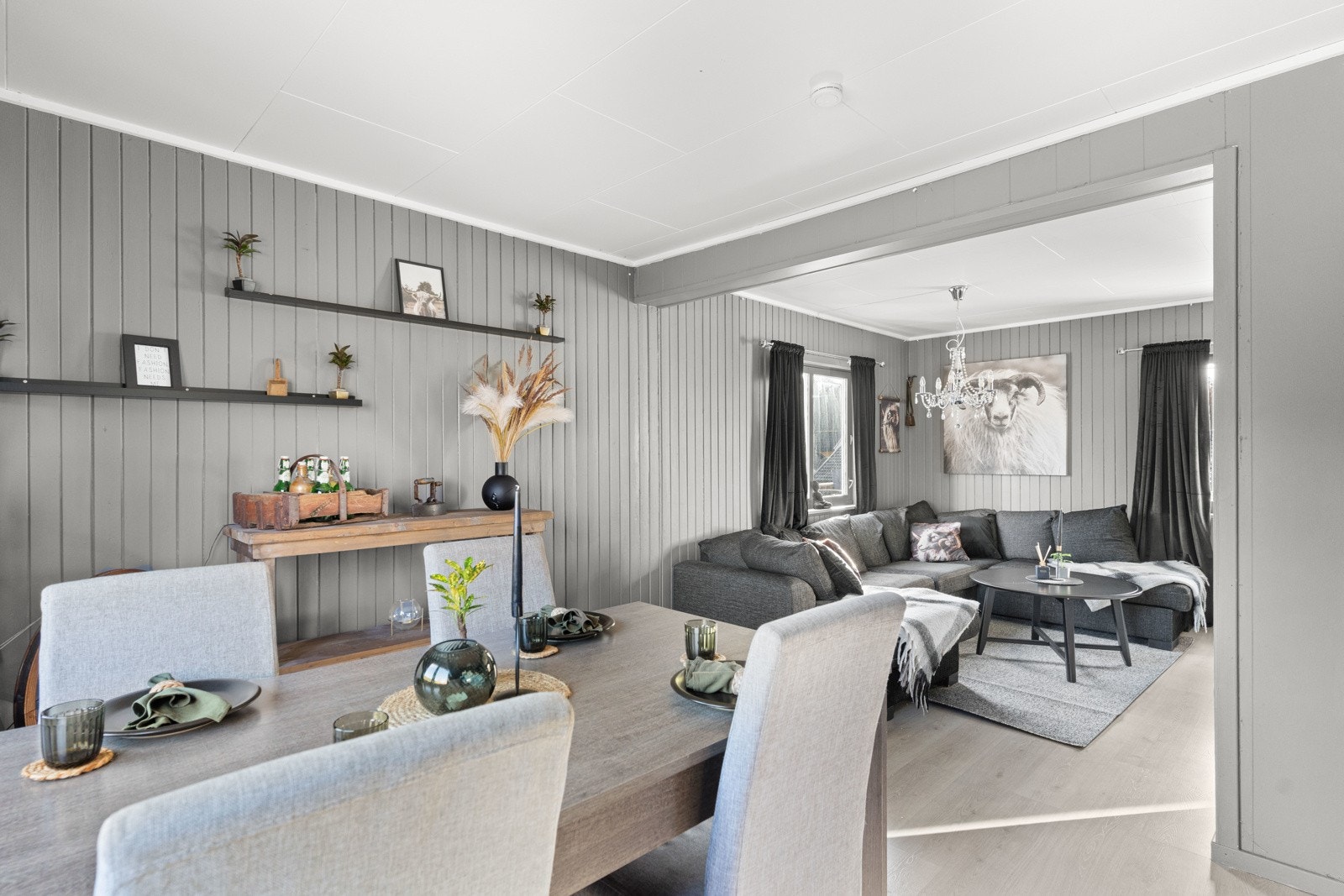 Selv med mørkere vegger og møblement, blir stuen lys og åpen på dagtid samtidig som man får den koselige lune stemningen på kvelden Galleribilde