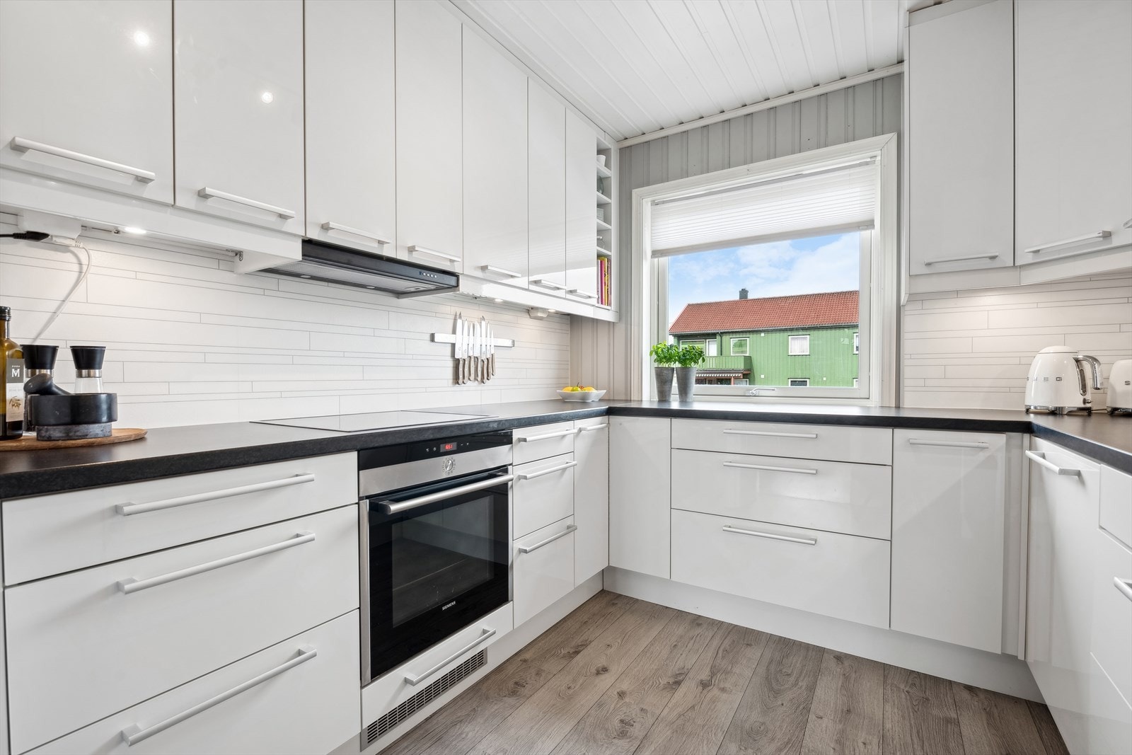 Videre er det belysning under overskap og det er montert Fibo trespo plater på veggene mellom kjøkkenbenker og overskap. Galleribilde