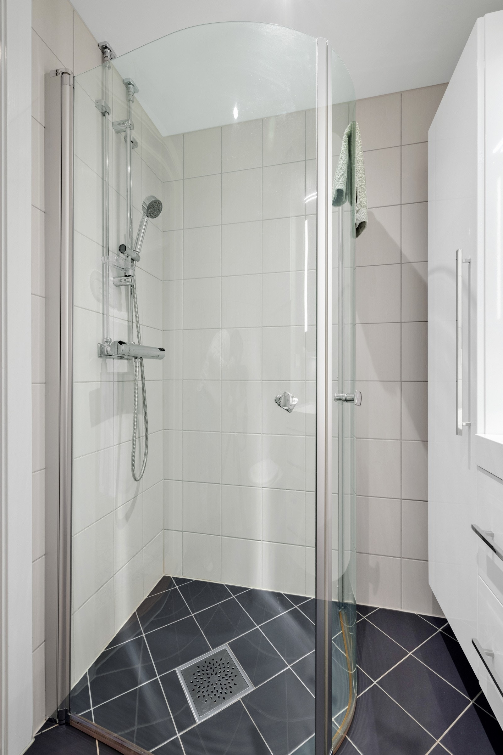Det er downlights og varmekabler, og badet har vegghengt toalett og et dusjhjørne med innfellbare glassdører Galleribilde