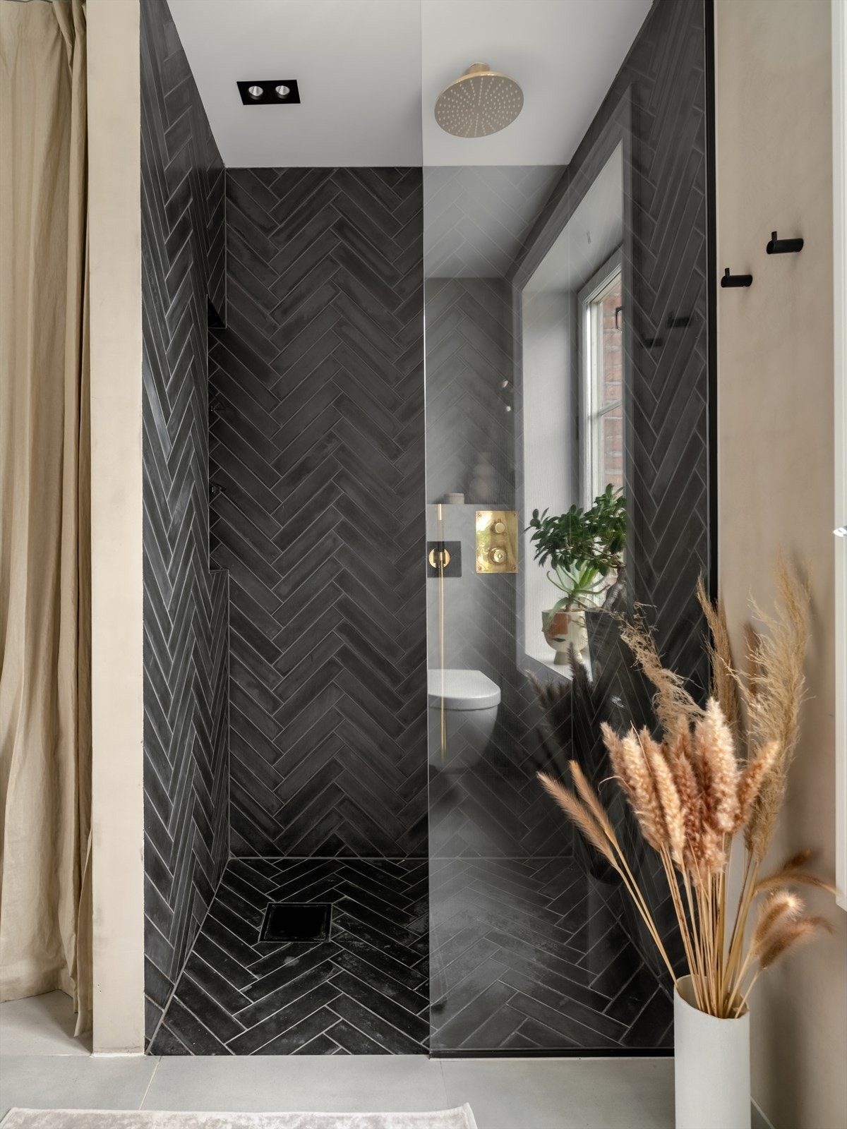 Det er håndlagde marokanske naturstein fliser i dusjsonen fra Cement STIX farge Kohl og armatur er fra tapwell. Galleribilde