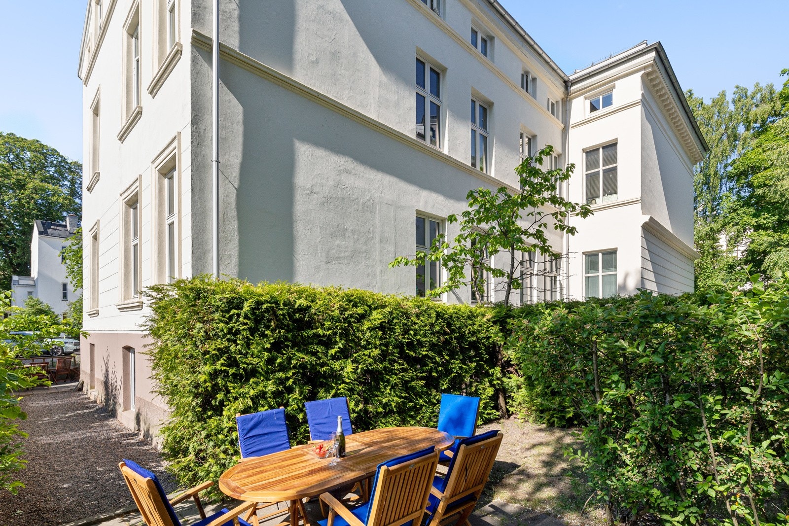 Tomten er pent opparbeidet med vakre blomster, busker og plantet hekk. Galleribilde