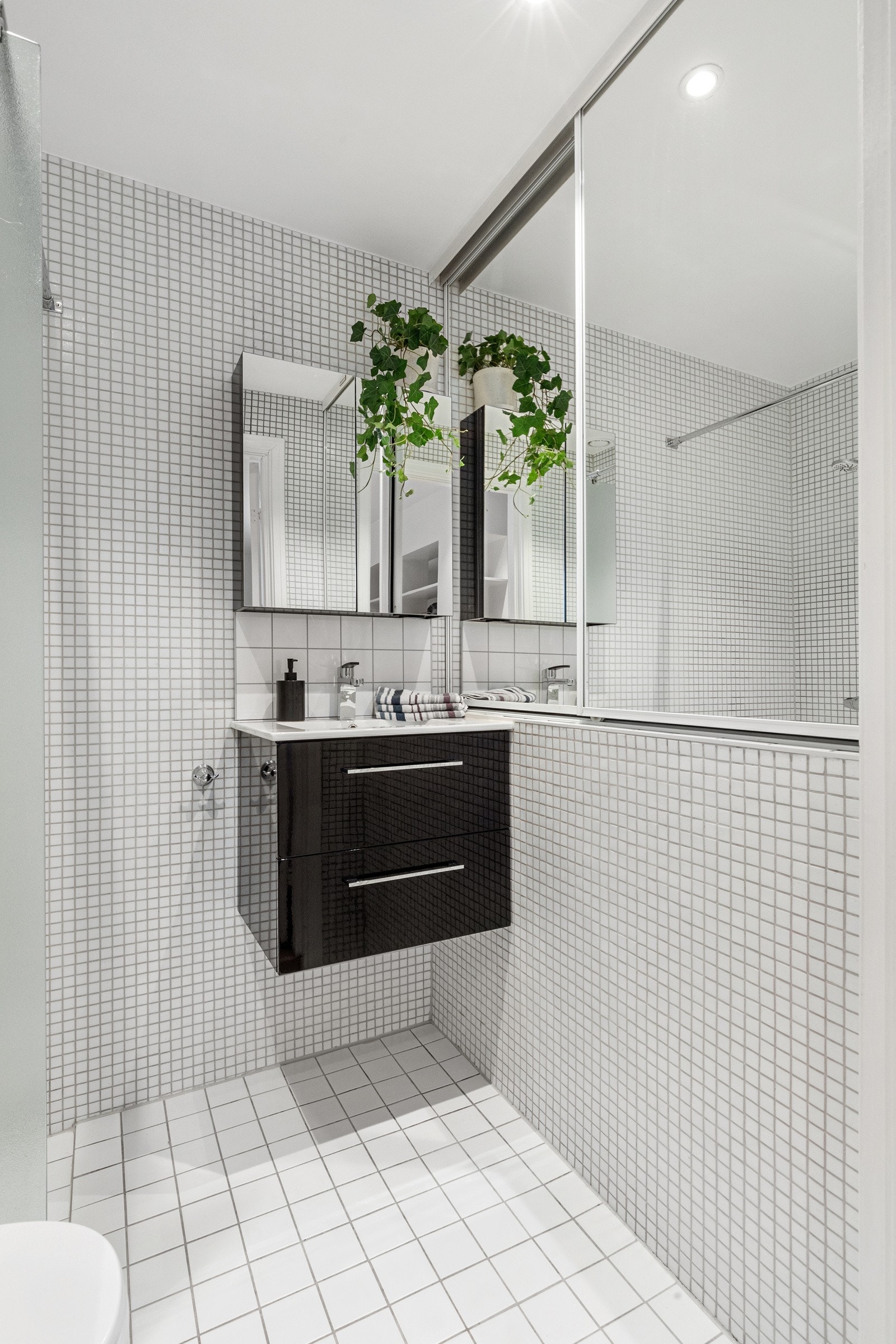 Baderommet inneholder benkeskap med servant i helstøpt plate og veggskap med speilfronter. Galleribilde