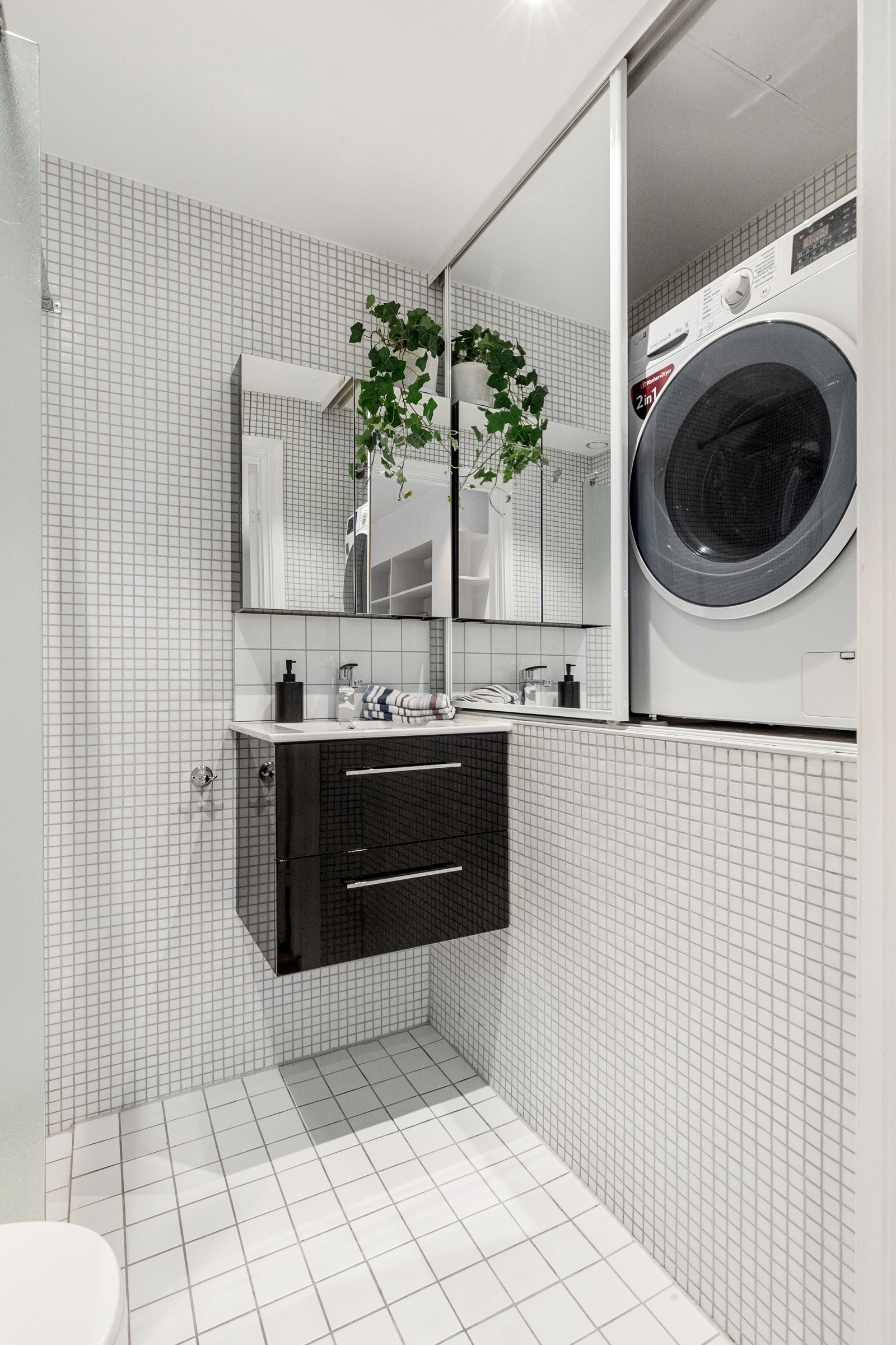 idere er det dusj med fast felt i herdet glass, toalett og opplegg for vaskemaskin i praktisk skyvedørsskap med speilfronter. Galleribilde