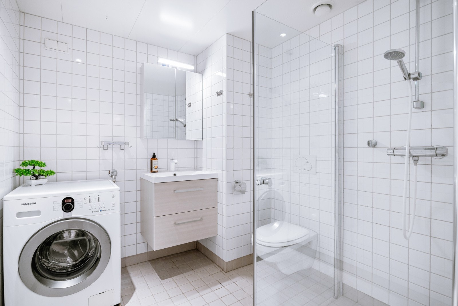 Delikat flislagt bad med varmekabler i gulv og dowblights i himling Galleribilde