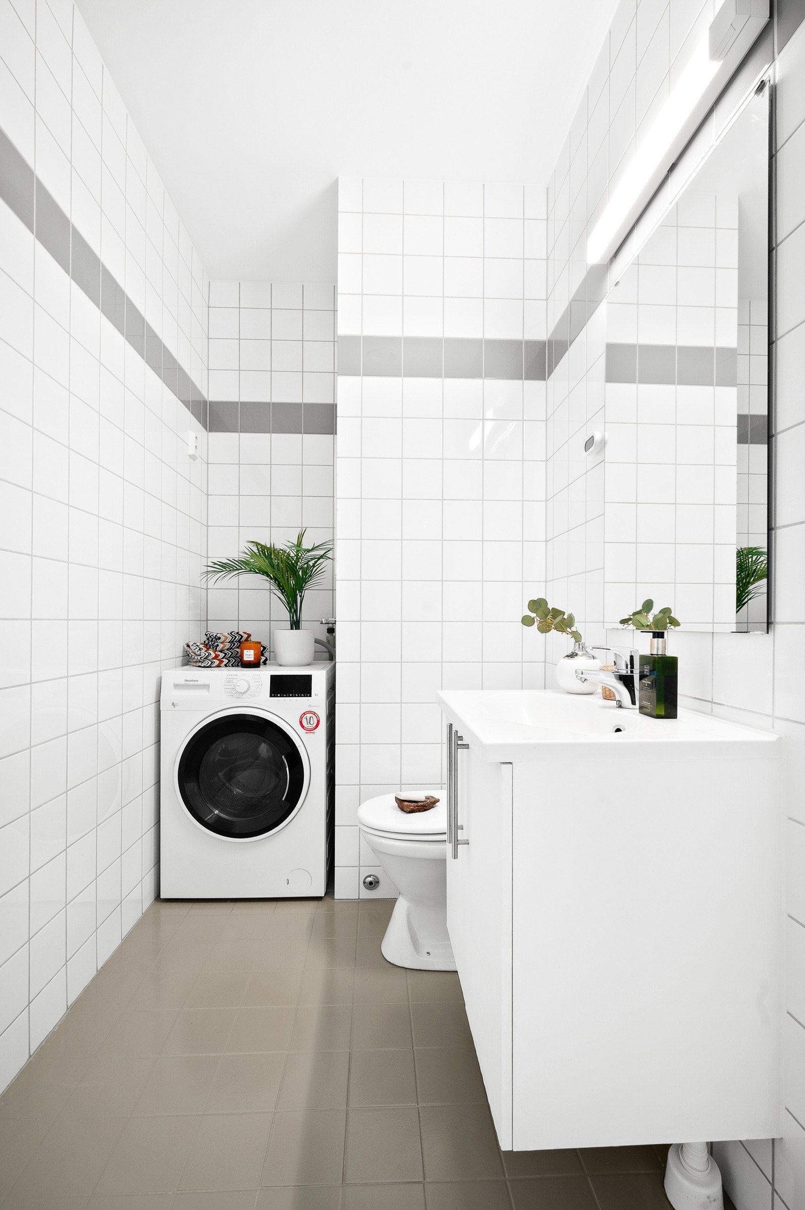 Badet har flislagte gulv og vegger, opplegg for vaskemaskin og plass til tørketrommel. Det er selvsagt også gulvvarme på badet. Galleribilde