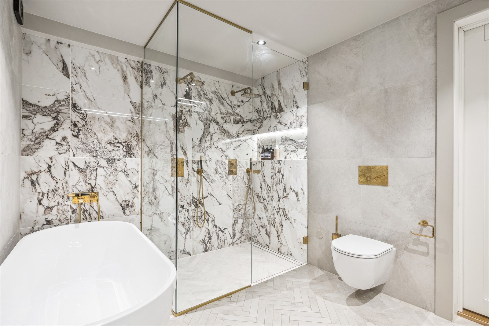 Det største badet er også flislagt, og har både dusj og badekar Galleribilde