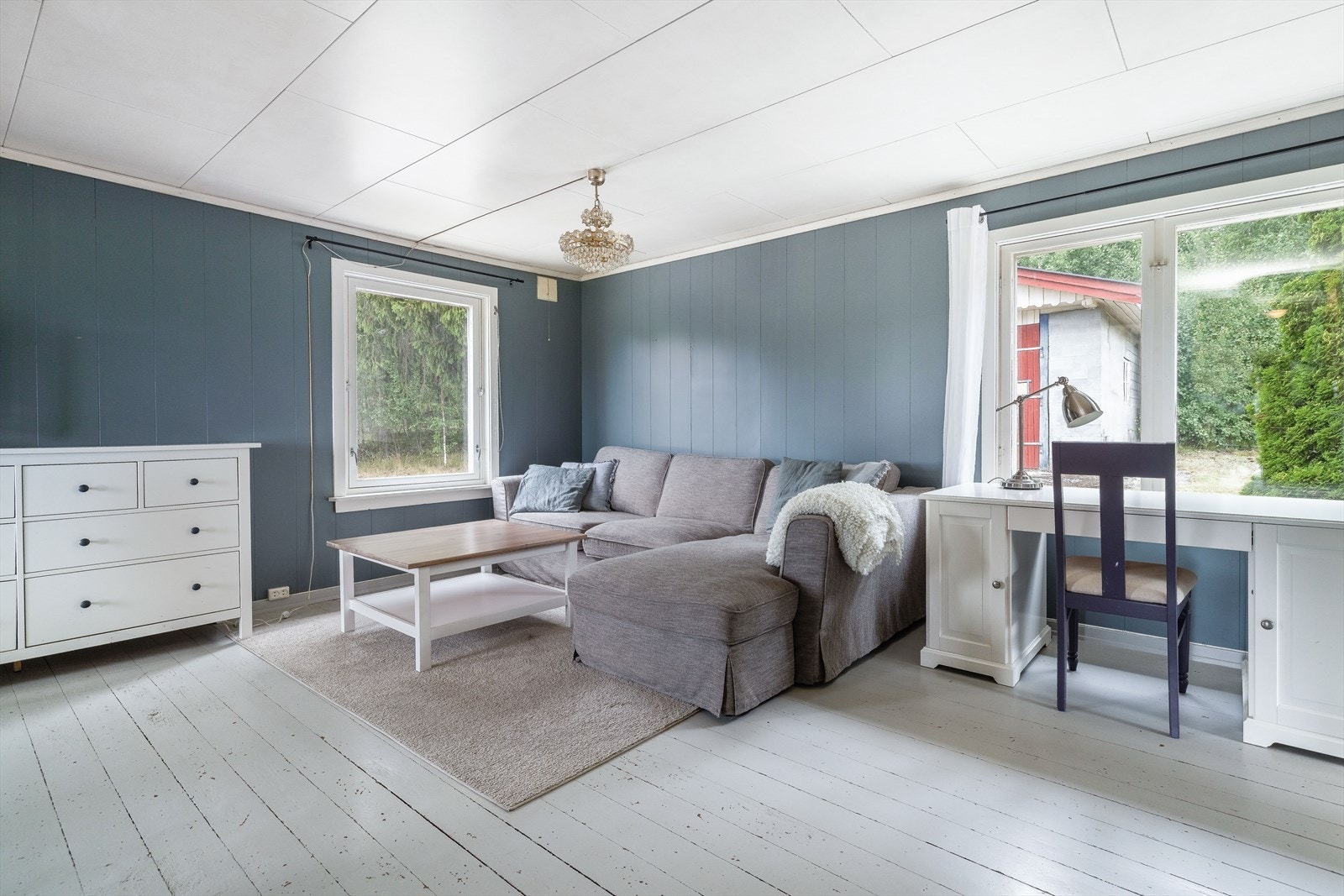 Overflater i denne stuen består av malt tregulv, malt panel på vegger og takessplater i himling. Galleribilde