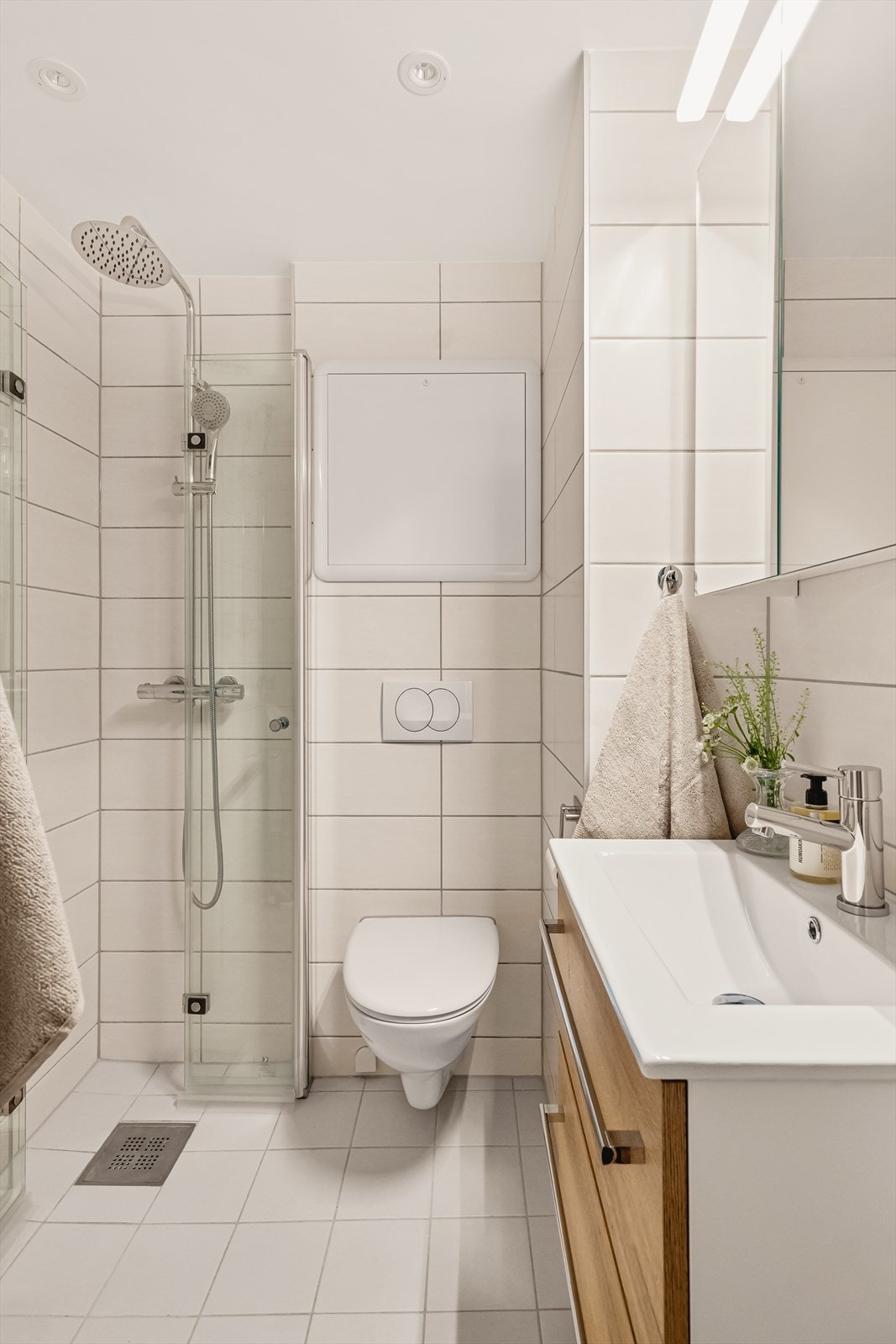 Badet inneholder vegghengt toalett, helstøpt servant, baderomsmøbler, dusj, opplegg for vaskemaskin og fordelerskap til rørsystem Galleribilde