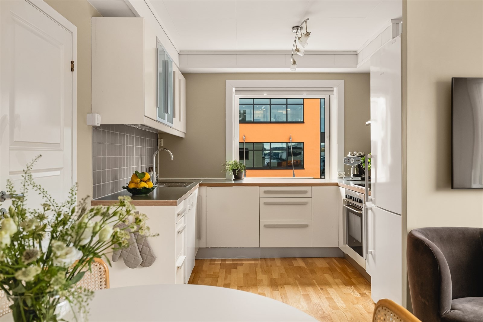 Kjøkkenet har innredning med slette fronter, laminat benkeplate, stål oppvaskkum og ventilator Galleribilde