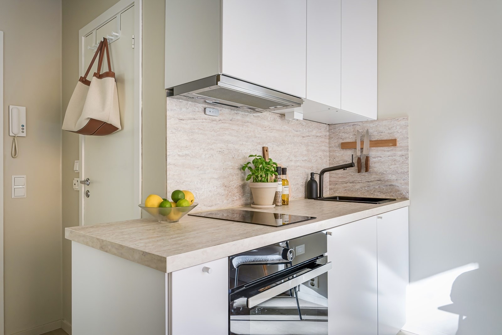 Kjøkkenet har innredning med glatte fronter og integrert kjøleskap, stekeovn og platetopp Galleribilde