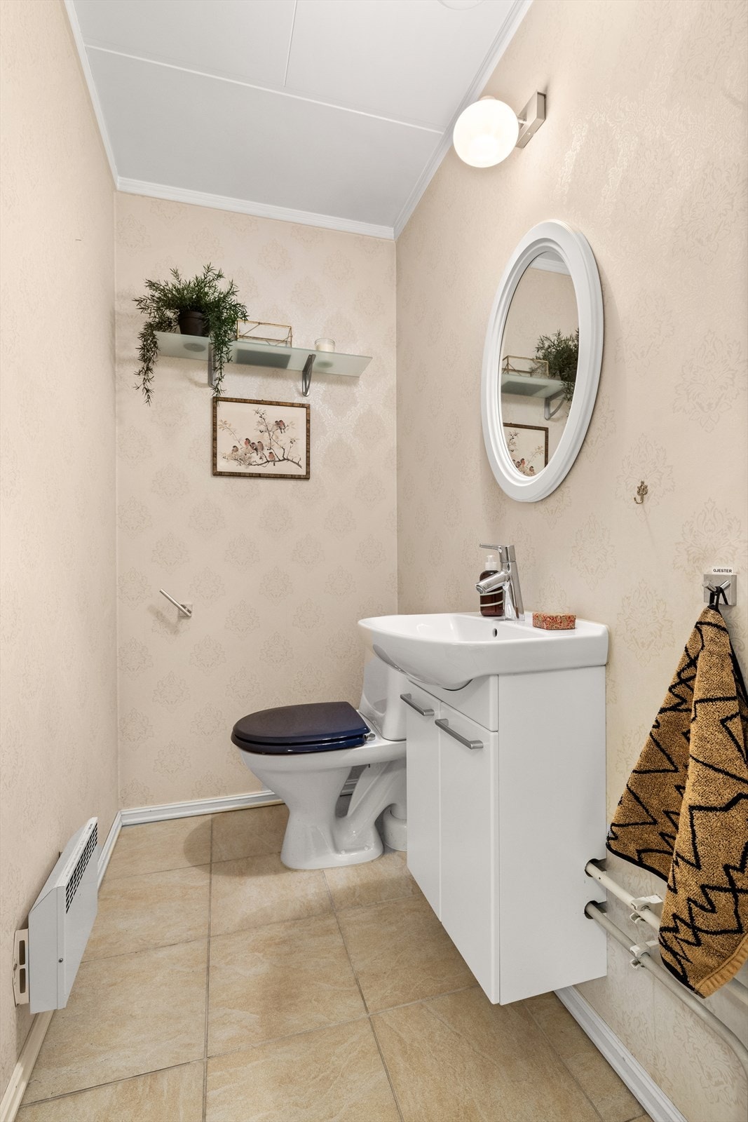 Separat gjestetoalett som ligger i praktisk tilknytningen til entréen/gangen. Toalettrommet er innredet med fliser på gulv, vegghengt servantinnredning med heldekkende servant, speil og belysning, samt toalett Galleribilde