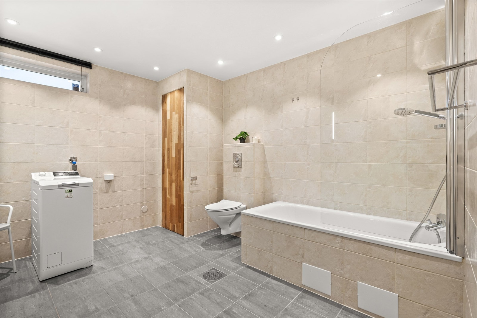 ... samt badekar med innfellbar skillevegg av glass og dusjarmatur tilkoblet hånddusj, vegghengt toalett og opplegg for vaskemaskin og tørketrommel. Her er også varmtvannsbereder fra 2008 på 300L plassert Galleribilde