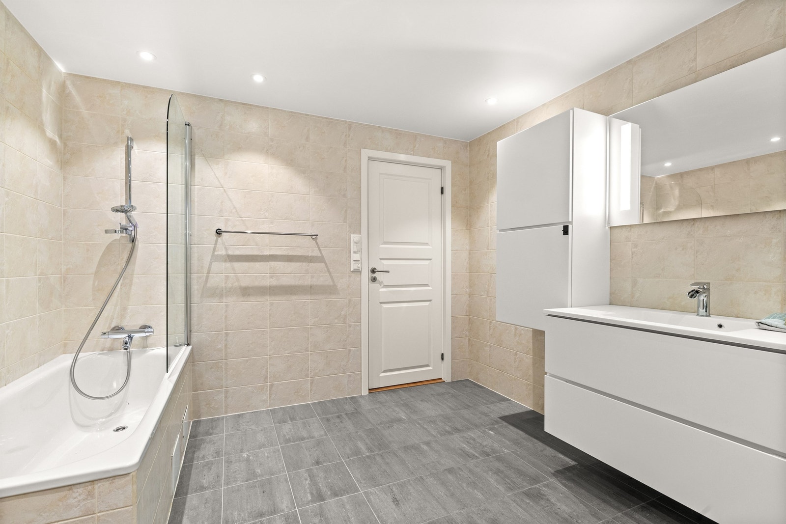 Hjemmets andre baderom ligger i underetasjen. Et stort baderom som ble pusset opp i 2008, med fliser på vegger og gulv, samt gulvvarme. Downlights i tak Galleribilde