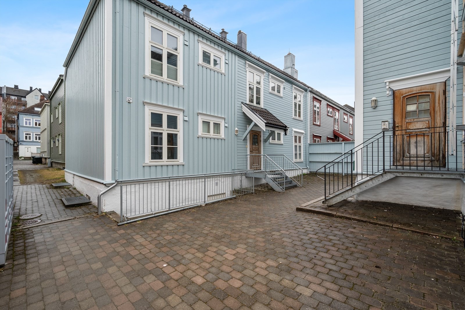 Fellesområdet består av et skjermet gårdsroms med brosteinsbelagt dekke, gjerder og sykkelparkering. Galleribilde