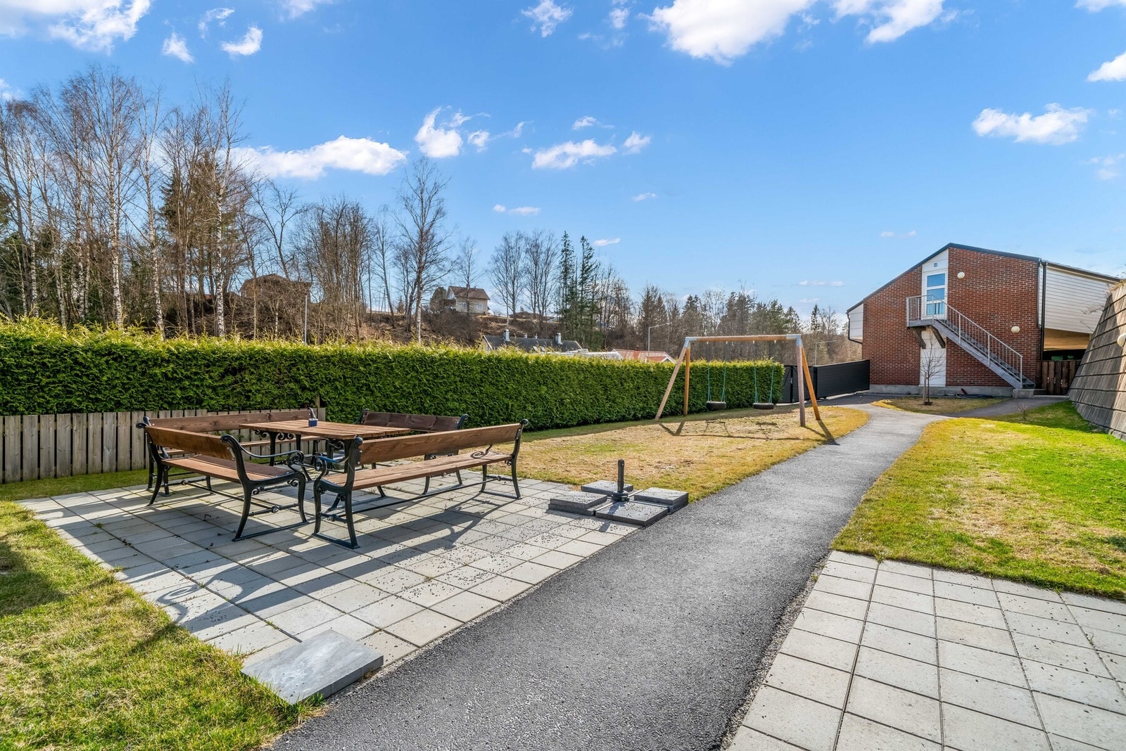 Det er et usjenert og hyggelig fellesområde på tomten, skjermet for innsyn med hekk og gjerde. Galleribilde