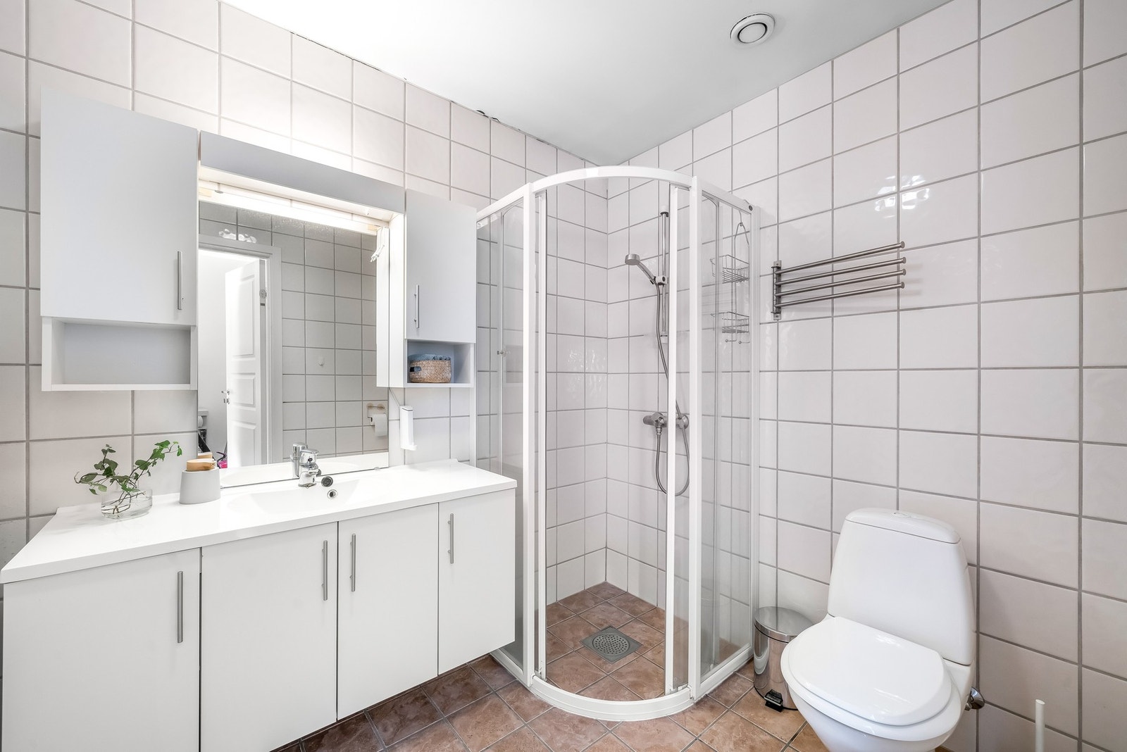 Badet er praktisk med fliser på gulv og vegg. Varmekabler i gulvet. Galleribilde