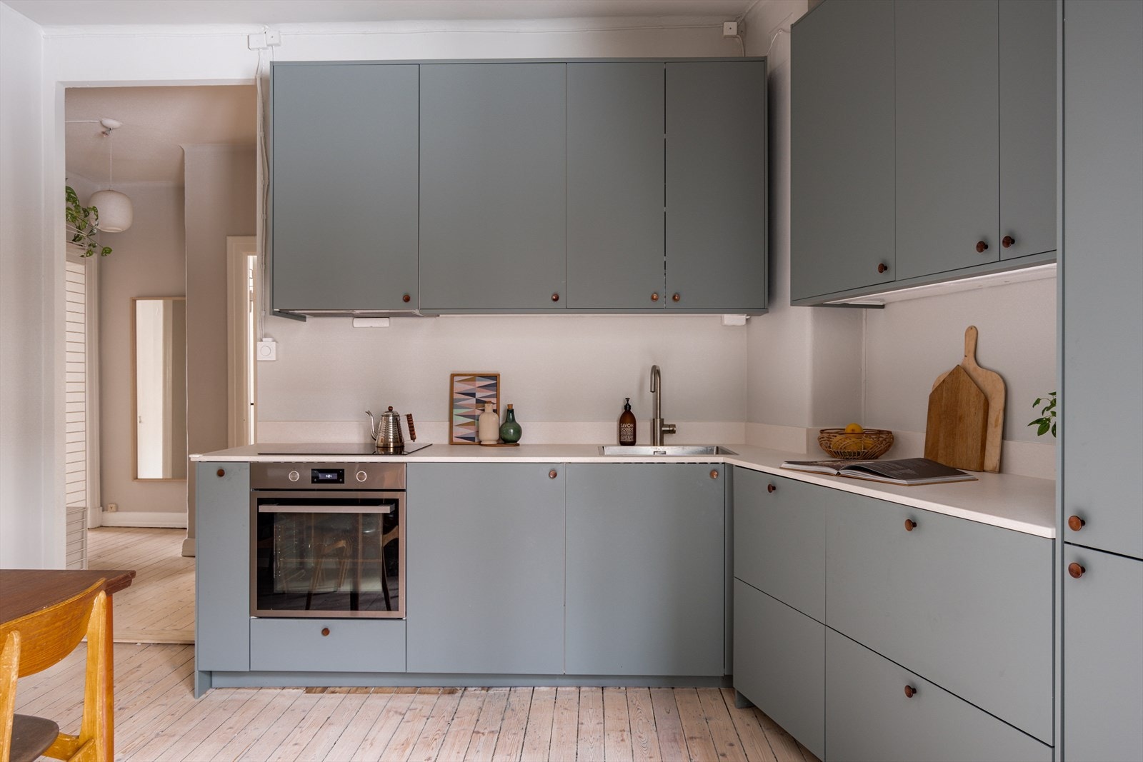 Innredningen består av glatte, folierte fronter, keramikkbenkeplate, nedfelt kum i rustfritt stål og lys under overskap. Galleribilde