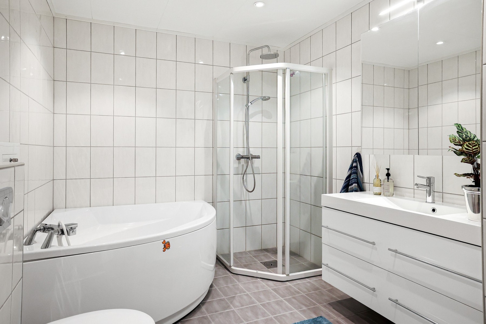 Rommet har innredning med nedfelt servant, veggmontert toalett, dusjhjørne, badekar og opplegg for vaskemaskin. Galleribilde