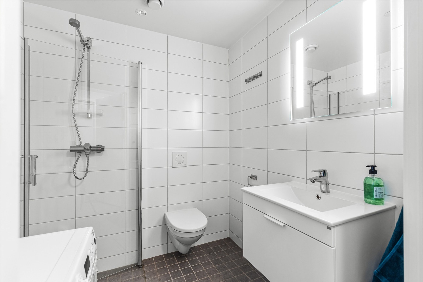 Lyst og moderne bad med flis på gulv og vegger, samt varmekabler i gulv som sørger for en god og lun følelse. Galleribilde