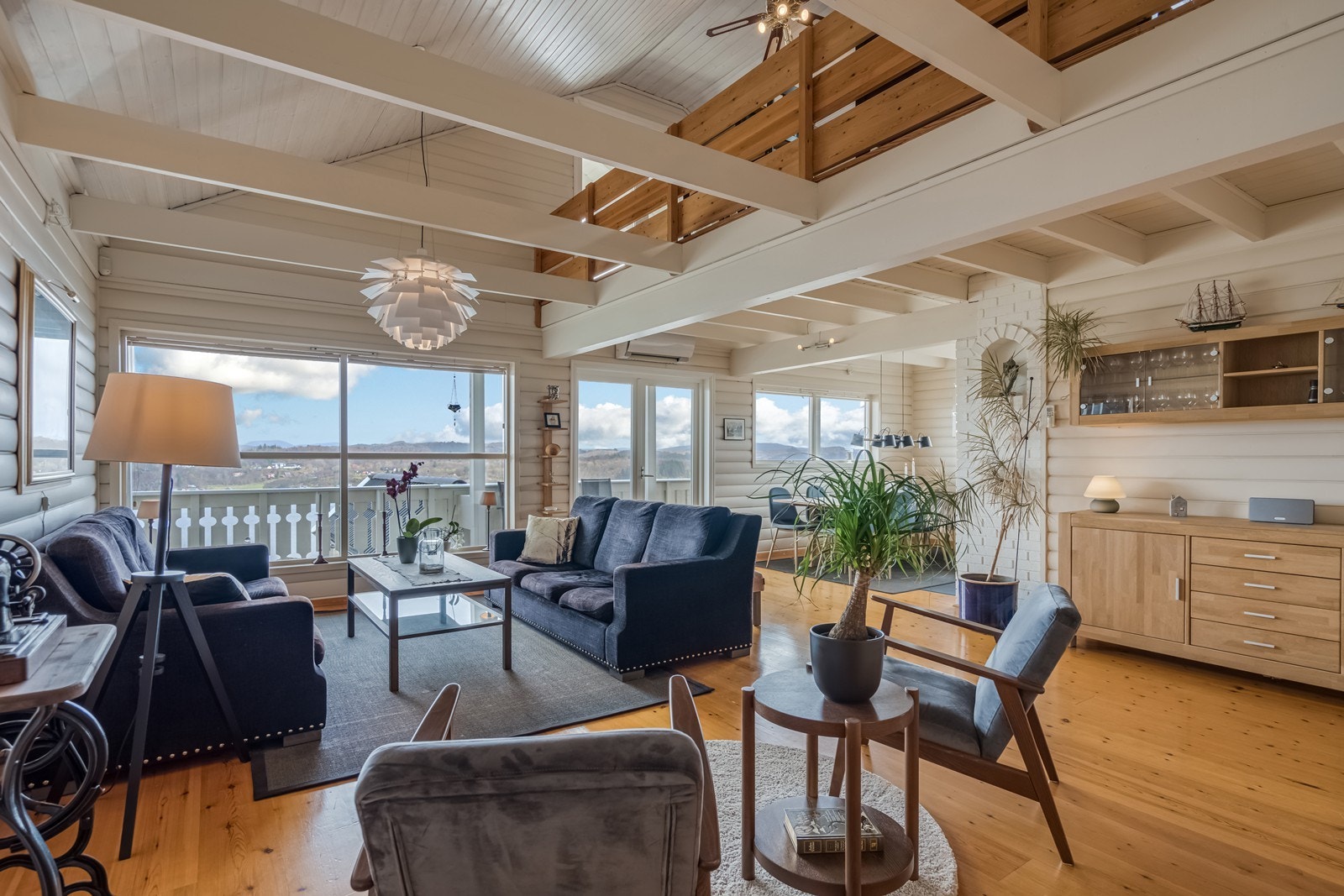 Trapp opp til stue med trapp videre opp til loft. Det er lakket en stavs furgulv og malt tapet på vegger. Varmepumpe og vedovn i kleberstein. Åpen løsning og svært god takhøyde opp til hems/loft. Galleribilde